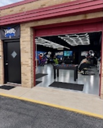 Outside entrance to Limited Barbershop with red trim and the open shop visible inside